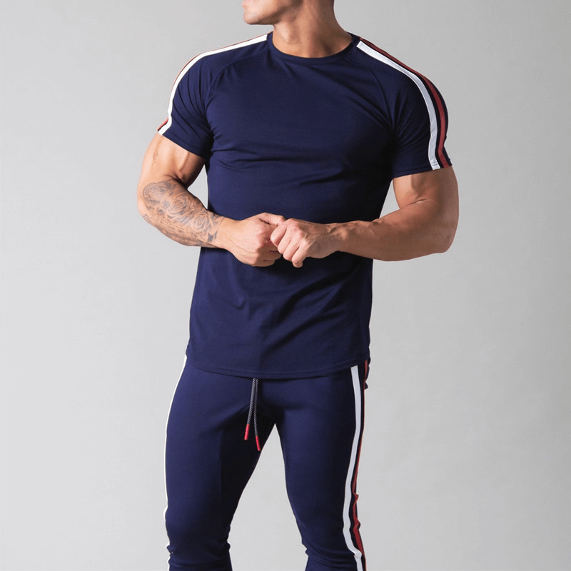 Men's navy cotton running t-shirt with striped sleeves, short sleeves, and an O-neck collar, model showcasing stylish fitness apparel.